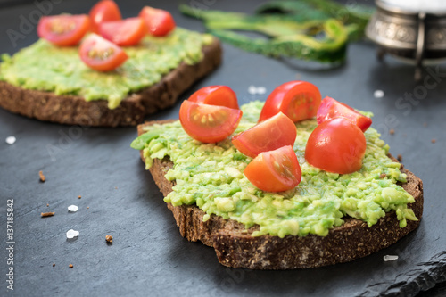 Toast with avocado, cherry tomatoes and spices. Healthy eating concept