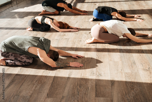 Obraz na plátně Group of people relaxing and practicing yoga