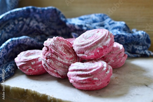 Pink colored marshmallows on a marble board