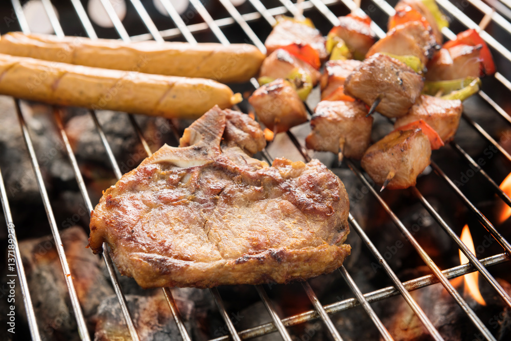 Assorted delicious grilled meat over the coals on a barbecue Assorted delicious grilled meat over the coals on a barbecue