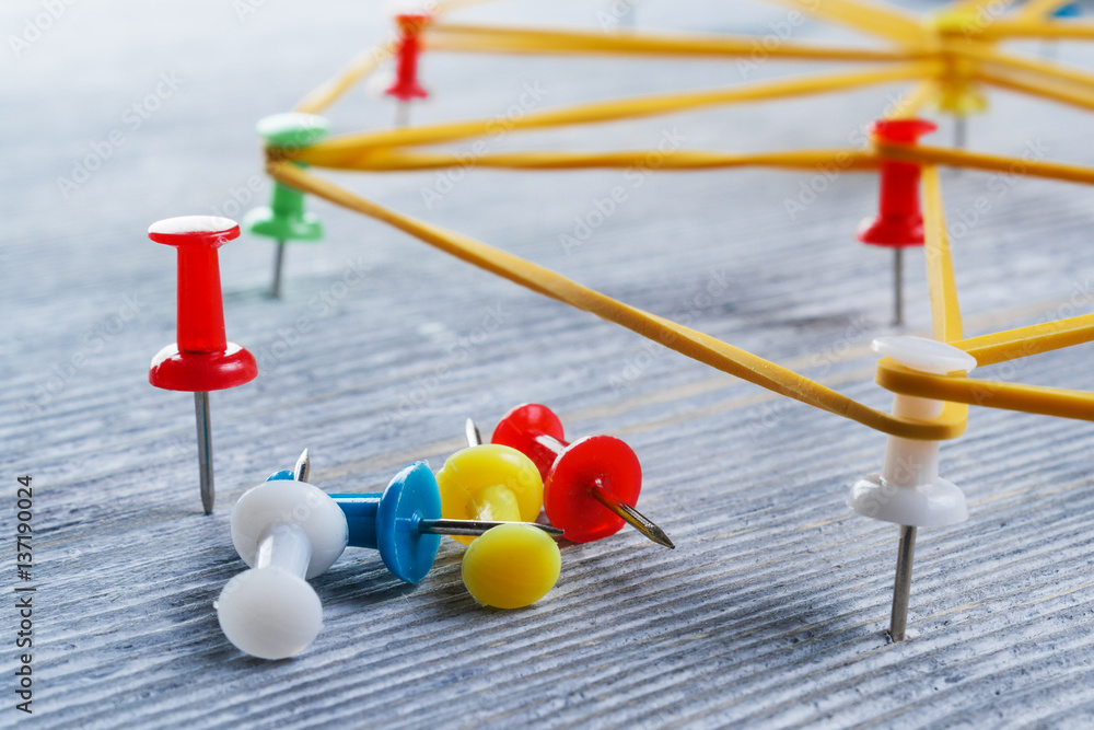 The concept of society. Drawing pins and rubber bands for money on a wooden surface. The concept of society. Drawing pins and rubber bands for money on a wooden surface.