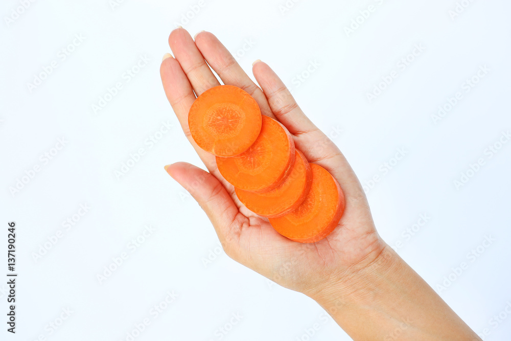 Slice of carrot in woman's hand on white background Slice of carrot in woman's hand on white background
