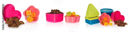 Multi colored kitchen molds with raisins and candy. Box closed in the shape of heart,  star, asquare and a circle. Containers in the colors blue, dark blue, yellow, pink, red. photo