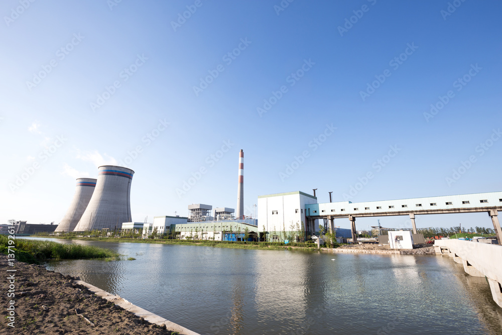 modern power plant near river in blue sky modern power plant near river in blue sky