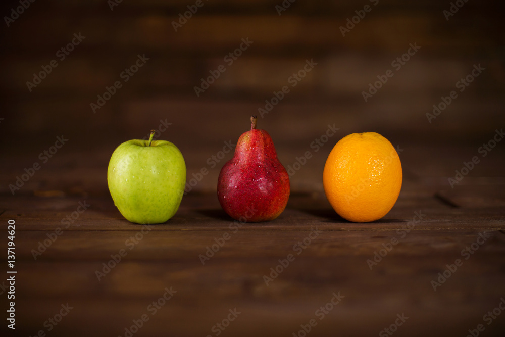 Apple, pear and orange on a wooden table