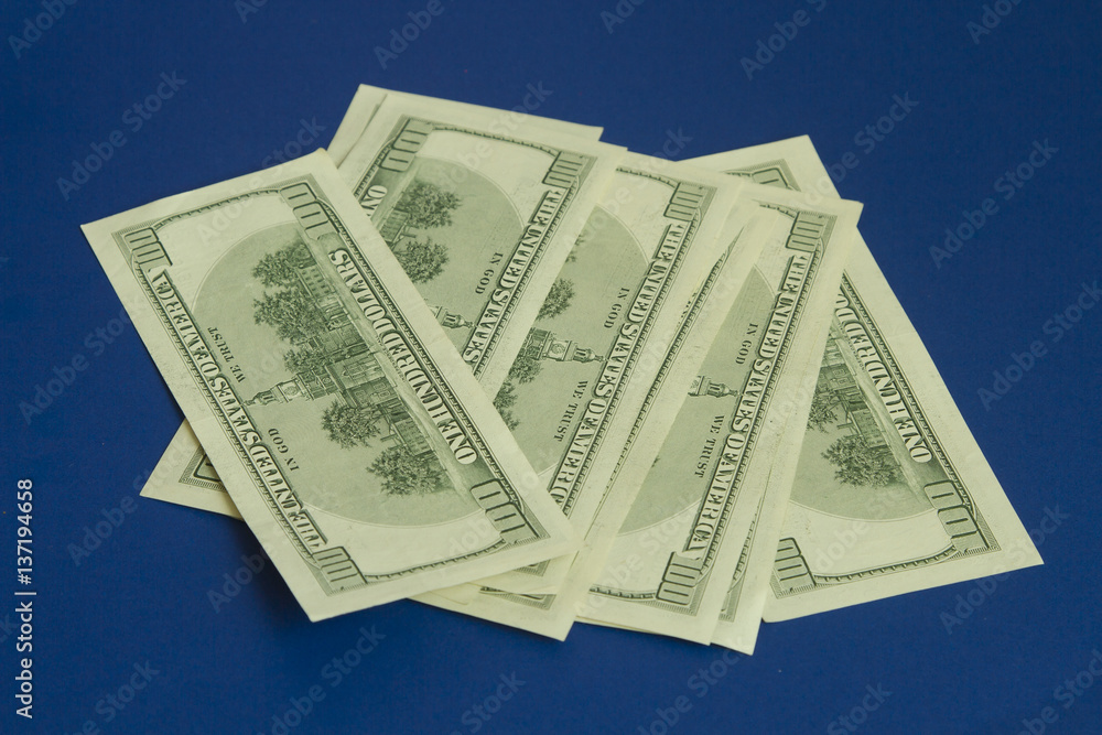Hundred dollar bills on dark blue background Hundred dollar bills on dark blue background