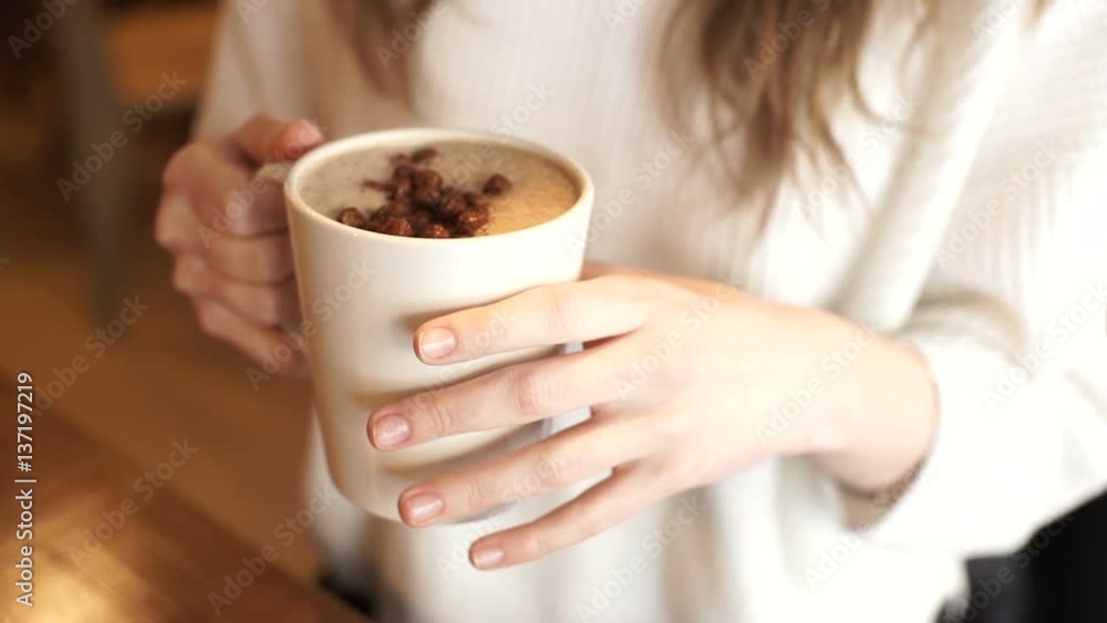 Closeup of female hands holding a cup of coffee. close-up of female hands with a mug of coffee in hand Closeup of female hands holding a cup of coffee. close-up of female hands with a mug of coffee in hand