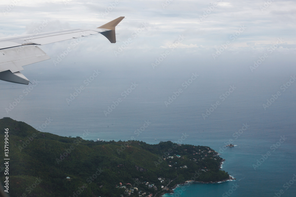 Airplane flying above beach sea blue island - Trave Concept