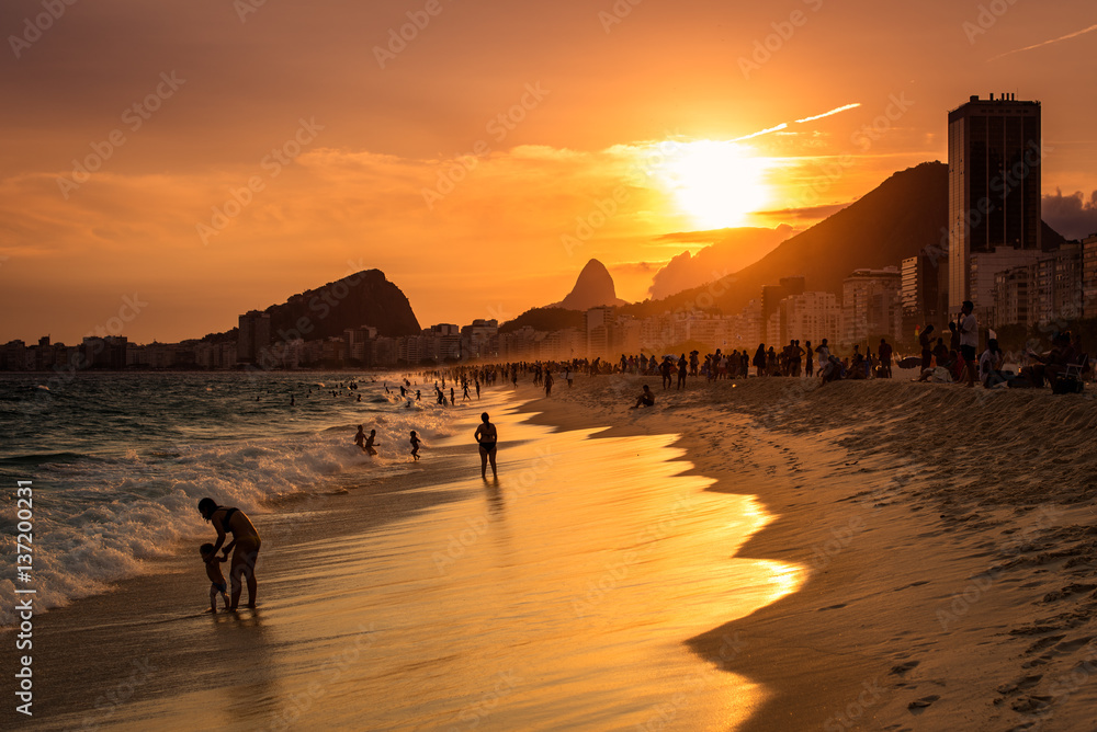 Obraz premium Sunset View in Copacabana Beach with Mountains in Horizon and Tall Hotel Building, Rio de Janeiro