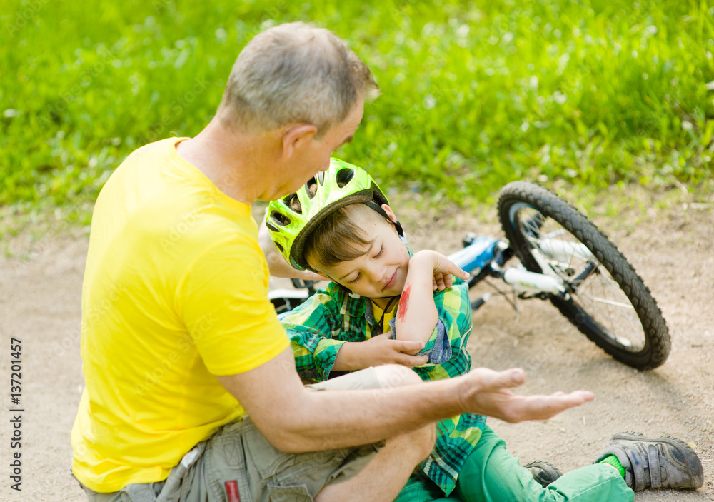 Old man inspects the injured child had fallen off the bike Old man inspects the injured child had fallen off the bike