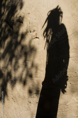 Shadows of people in various  stance on soil background.