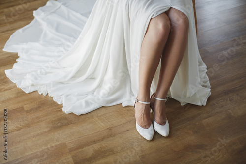 bride puts on white shoes on feet