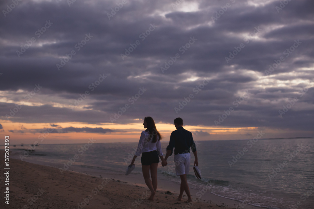 Young couple enjoying the sunset on the beach