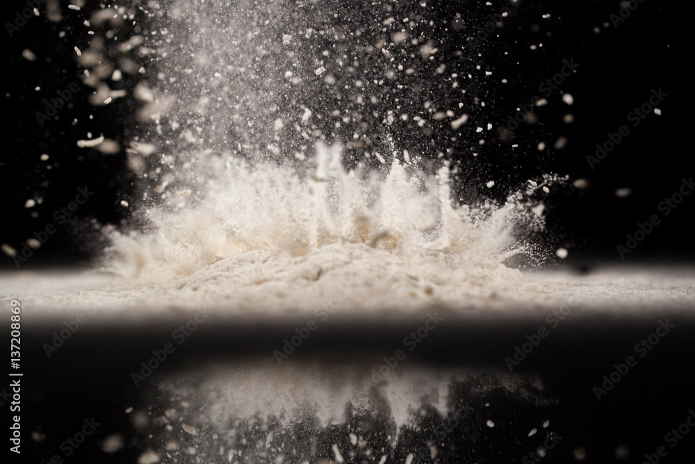 The loose flour lies on the black background The loose flour lies on the black background