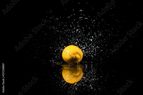 The lemon with drops  stands on the black background