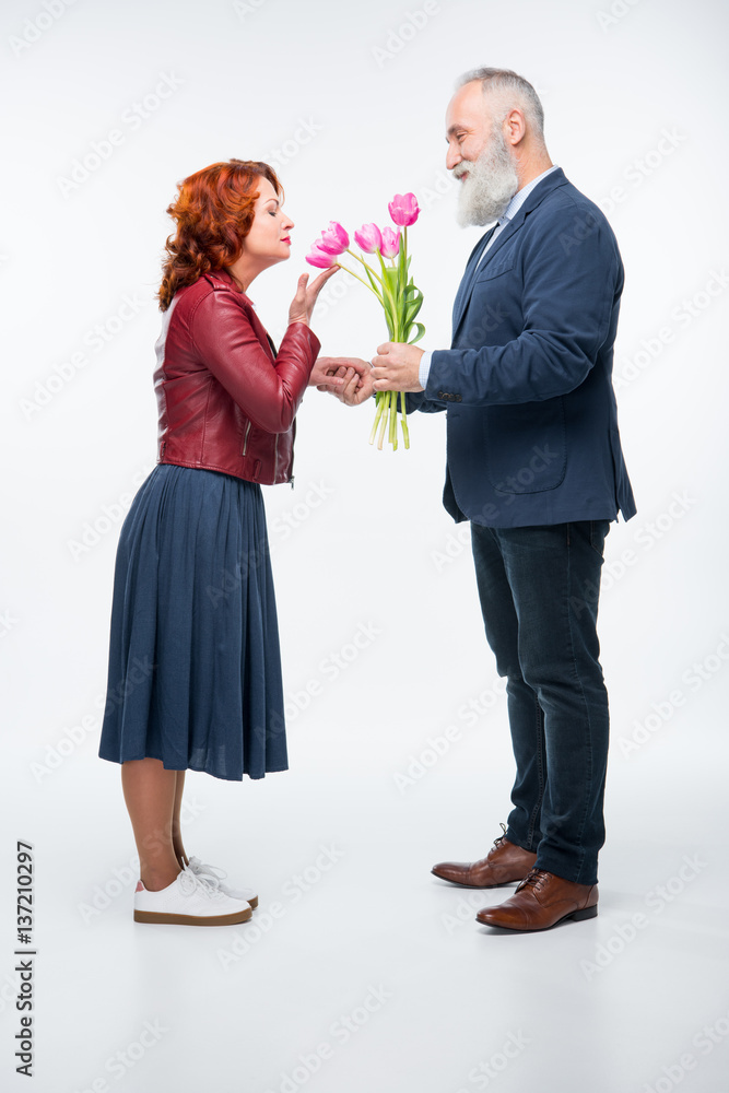 Man presenting flowers to woman Man presenting flowers to woman