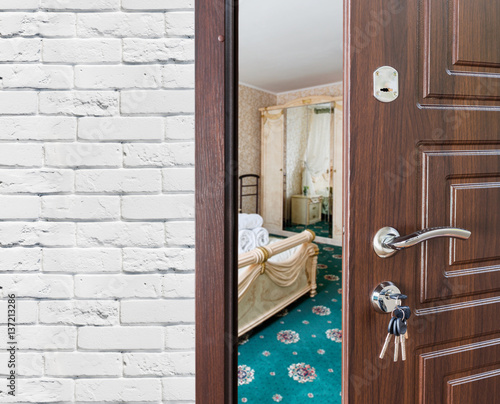Half open door of a classic bedroom, handle closeup.