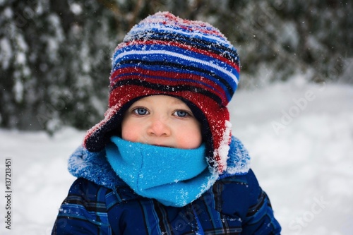 adorable toddler boy sitting in snow during winter