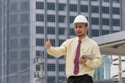 Business man thumbs thumb A confident stance, with the backdrop of the buildings in the city.