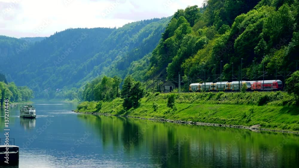 A small train station on a riverbank in a rural area A small train station on a riverbank in a rural area