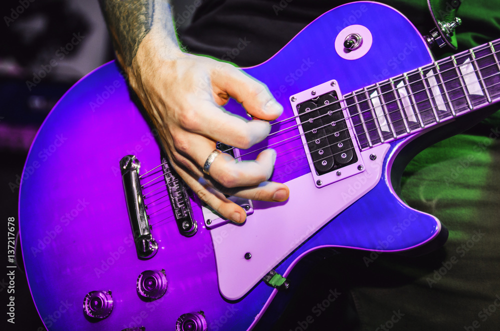 Musician Blurred hands on purple guitar string guitar closeup