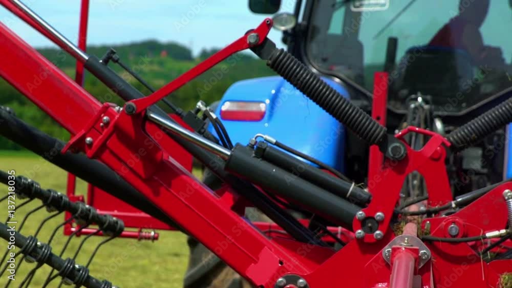A farmer is pushing a button in his tractor and the machinery starts moving up very slowly.
A farmer is pushing a button in his tractor and the machinery starts moving up very slowly.