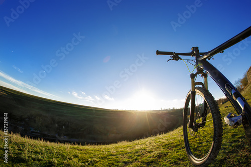 Mountain bike on journeys. Going up hills on small roads between green fields with blue sky.