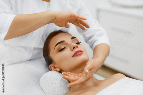 Beauty Treatment. Beautiful Woman Getting Face Head Massage