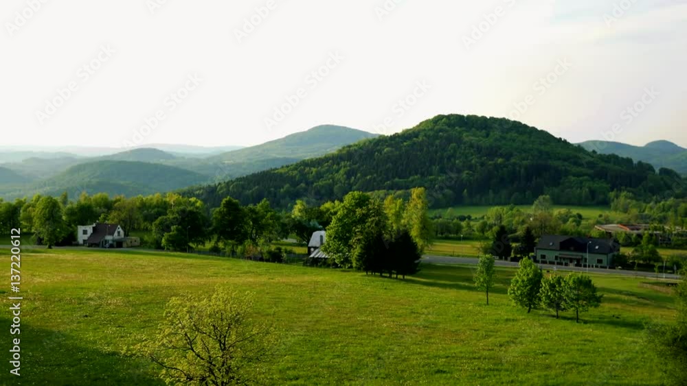 Houses in a rural area, a misty mountainous landscape in the background - top view Houses in a rural area, a misty mountainous landscape in the background - top view
