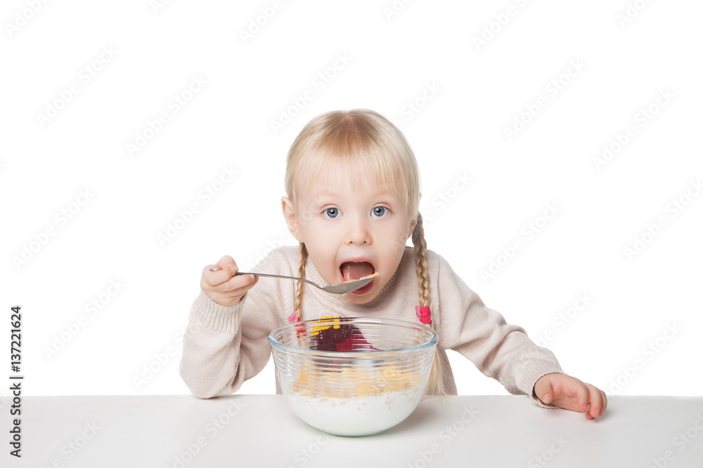 Smiling little girl eating flakes. Isolated on white background Smiling little girl eating flakes. Isolated on white background