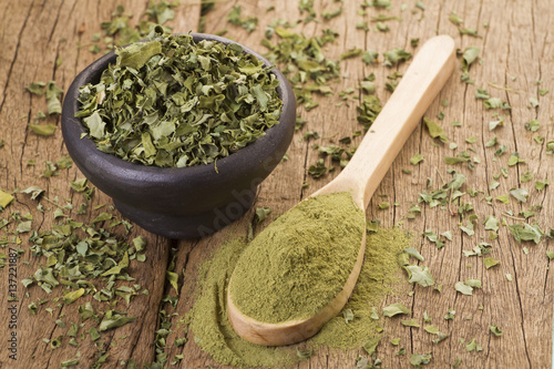 Dust and moringa leaves on wooden background 