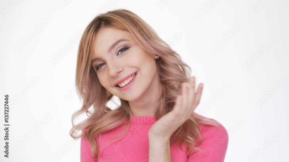 Smiling Woman in pink sweater which sands air kiss at camera Smiling Woman in pink sweater which sands air kiss at camera