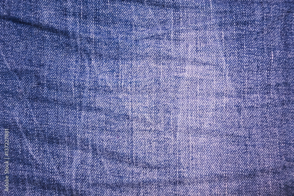 Background texture of blue jeans with a pattern of wrinkles Background texture of blue jeans with a pattern of wrinkles