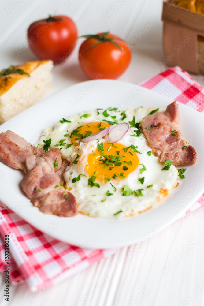 Fried eggs with bacon on white background