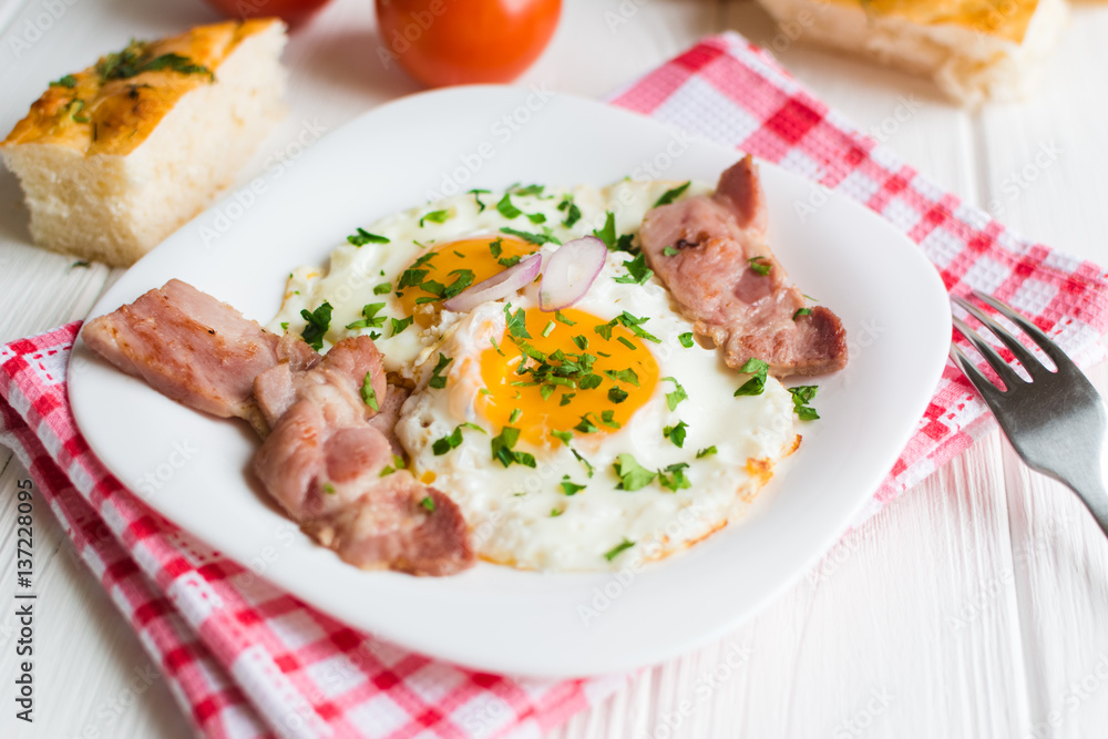Fried eggs with bacon on white background