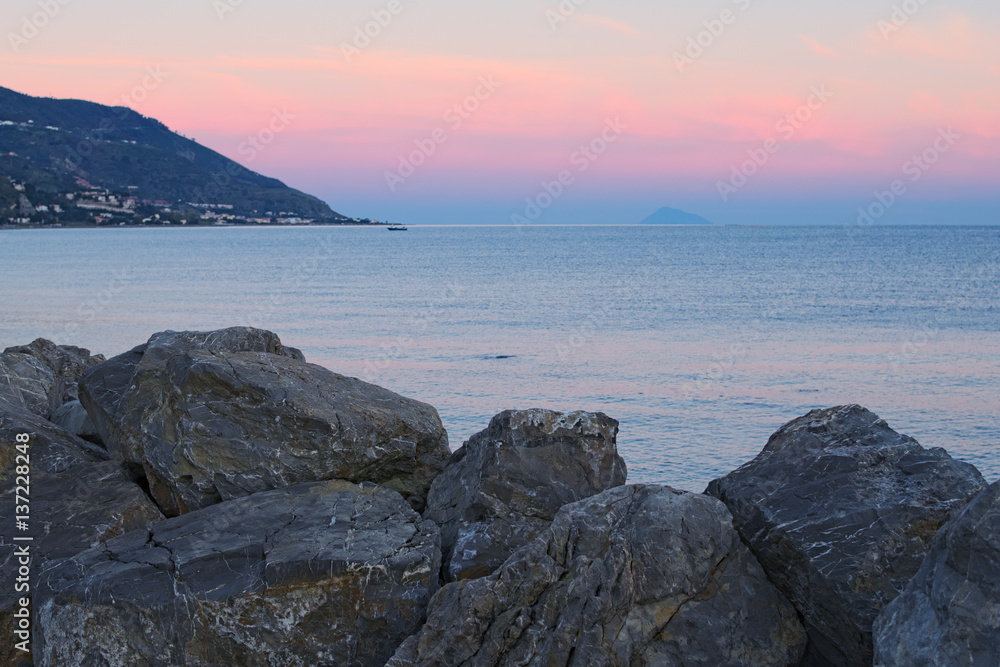 Sunset at the Tyrrhenian Sea. Large stones in the foreground. Marina di Patti. Sicily