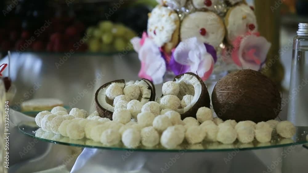Half coconut with coconut candies.Candies in coconut flakes and fresh coconut. Half coconut with coconut candies.Candies in coconut flakes and fresh coconut.