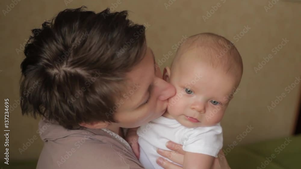 young pretty mother kissing her little baby with love young pretty mother kissing her little baby with love
