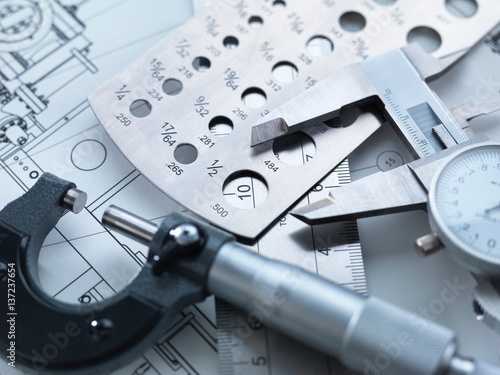 Engineering Measurement, Dial calipers sitting on a steel rule with micrometer and engineering drawings photo