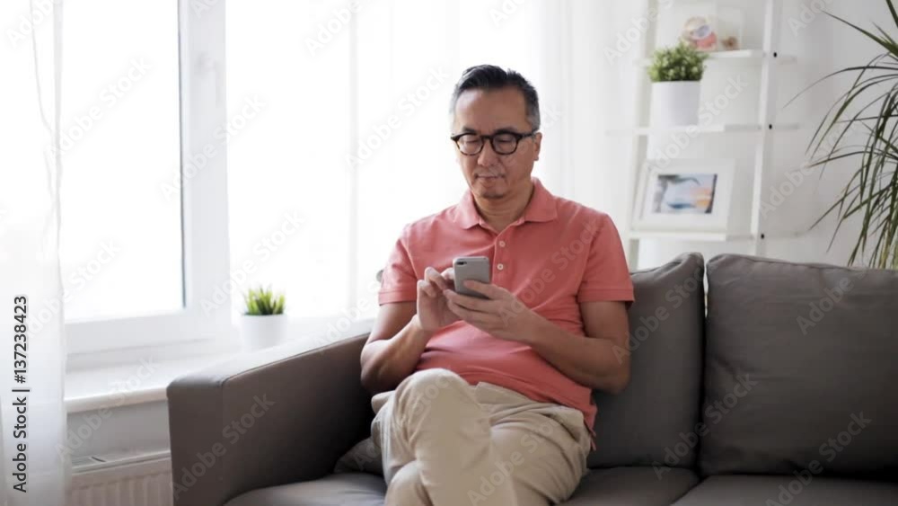 man with smartphone sitting on sofa at home man with smartphone sitting on sofa at home