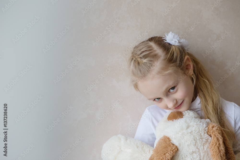 Smiling little girl holding a toy dog