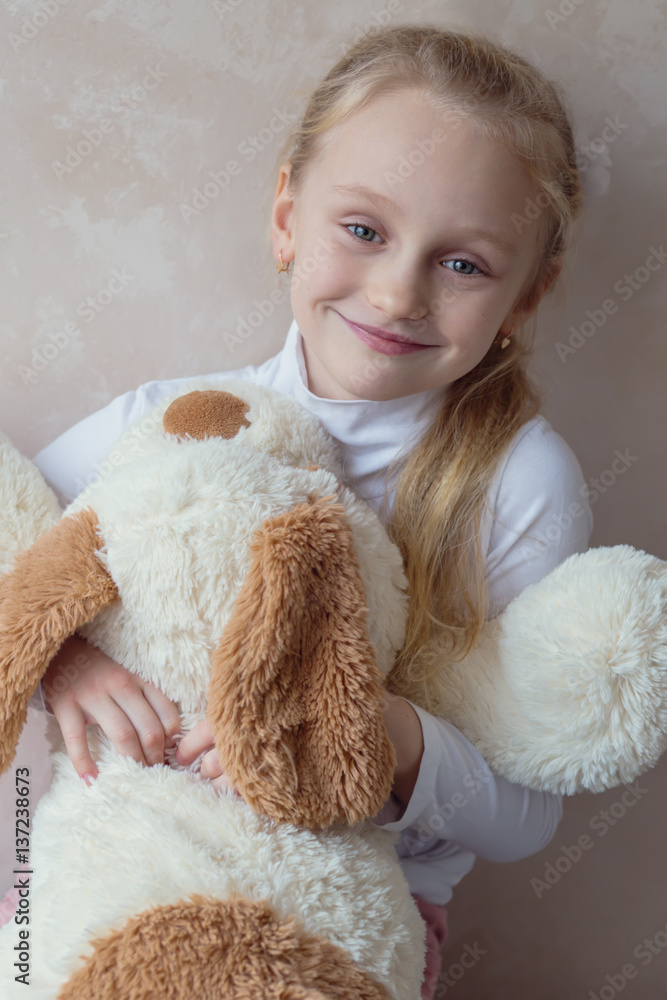 Smiling little girl holding a toy dog Smiling little girl holding a toy dog