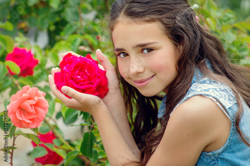 Portrait of brown-eyed little girl with a rose