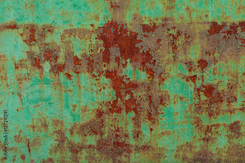 Rusty surface of green metal plate. Rusty texture backdrop. Rust on old metal. Rust on old green fence. Grunge ruststained metal fence. Mildew on green iron-plate fencing. Seedy bingery paling