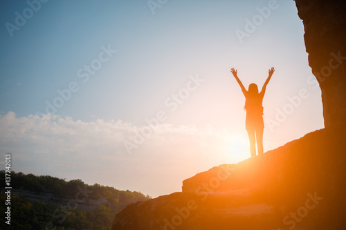 Woman on mountain against sun