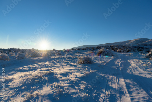 Sunset winter landscape with road and blue sky