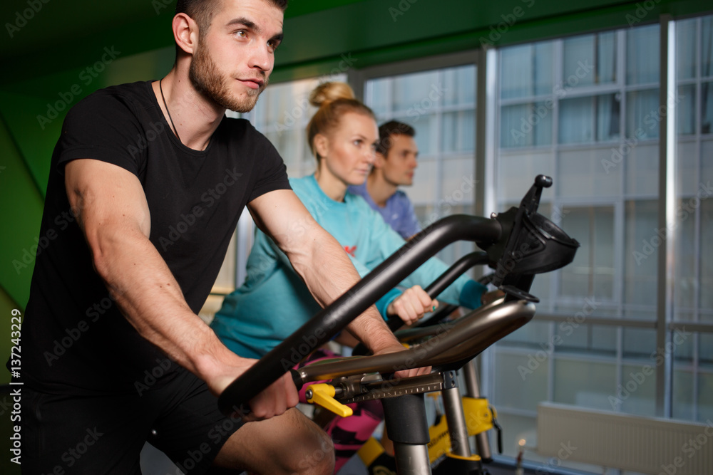 Young athletes on stationary bike Young athletes on stationary bike