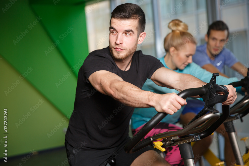 Sports people on exercise bikes