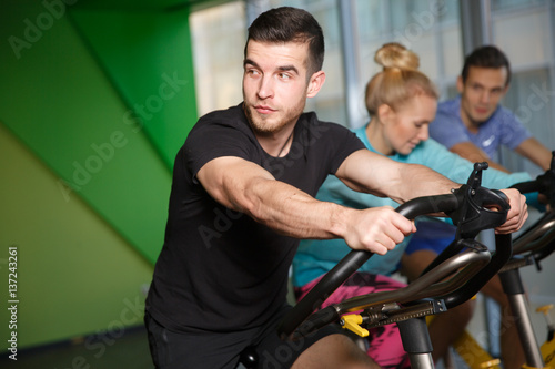 Sports people on exercise bikes
