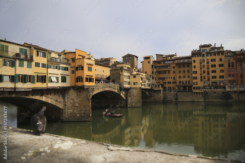 The Ponte Vecchio medieval stone closed-spandrel segmental arch bridge over the Arno River, in Florence, Italy, noted for still